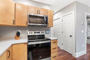 a kitchen with a stove and a microwave at Lower Lakeshore Living in Lake Junaluska +17 photos