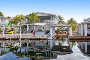 a house with a dock next to a body of water at LT04FLR Torchbearer - Lower in Little Torch Key