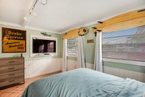 a bedroom with a bed and a tv and a window at LT04FLR Torchbearer - Lower in Little Torch Key