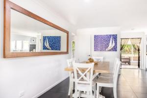 a dining room with a table and chairs and a mirror at SeaBreeze On Todd in Yeppoon