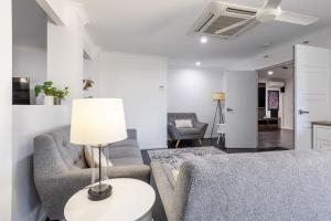 a living room with two chairs and a table with a lamp at SeaBreeze On Todd in Yeppoon +20 photos