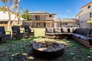 a backyard with a couch and chairs and a fire pit at SeaBreeze On Todd in Yeppoon