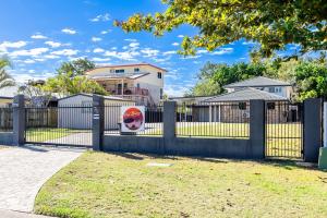 a fence with a gate with a skull painted on it at SeaBreeze On Todd in Yeppoon