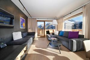uma sala de estar com um sofá e uma mesa em Chalet Hohe Welt - luxury apartments em Lech am Arlberg