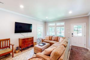 a living room with a couch and a flat screen tv at Hilltop Hideaway in Asheville