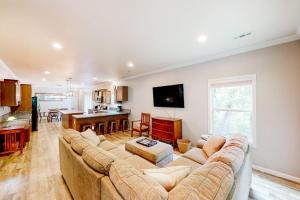 a living room with a large couch and a kitchen at Hilltop Hideaway in Asheville