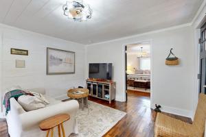 a living room with a white couch and a television at Meet Me At The Creek in Whittier