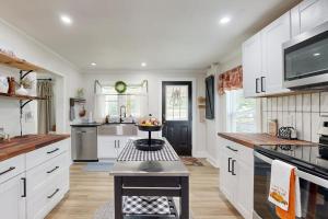 a kitchen with white cabinets and a table in it at Meet Me At The Creek in Whittier +13 photos