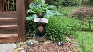 a garden statue of a bear with a welcome sign at Hickory Creek Hideaway in Maggie Valley