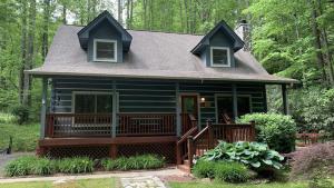 a small house with a large deck in the woods at Hickory Creek Hideaway in Maggie Valley +42 photos