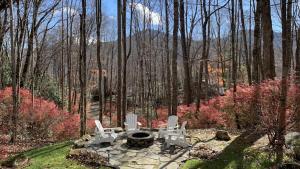 two chairs and a fire pit in the woods at Hickory Creek Hideaway in Maggie Valley