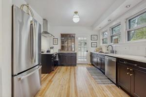a kitchen with a stainless steel refrigerator and wooden floors at Love Lane Tudor in Waynesville