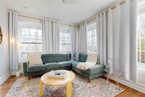 a living room with a green couch and a table at Love Lane Tudor in Waynesville +19 photos