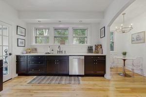 a kitchen with brown cabinets and a sink and a table at Love Lane Tudor in Waynesville