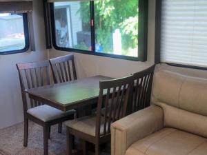 a table and two chairs and a table and a couch at Cozy Camper in Newfield +5 photos