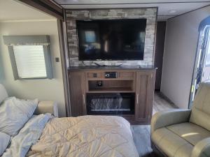 a living room with a tv and a fireplace at Cozy Camper in Newfield