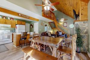 a living room with a wooden table and a kitchen at Smoky View Retreat in Maggie Valley