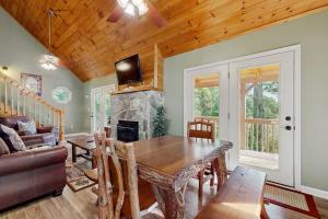 a living room with a table and a fireplace at Smoky View Retreat in Maggie Valley