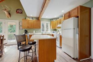 a kitchen with a white refrigerator and wooden cabinets at Smoky View Retreat in Maggie Valley