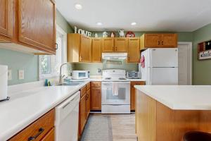 a kitchen with wooden cabinets and white appliances at Smoky View Retreat in Maggie Valley +12 photos