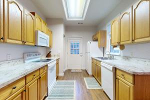 a kitchen with wooden cabinets and a white refrigerator at Mountain Hideaway in Sylva