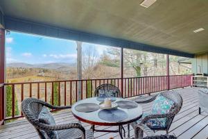 a patio with a table and chairs on a deck at Riverhill Ridge in Sylva