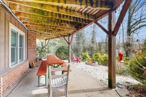 a patio with a table and a wooden pergola at Circular Mountain Retreat in Brevard +25 photos