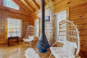 a living room with two wicker chairs and a fireplace at The Lovely Cabin in Black Mountain