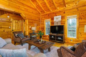 a living room with a couch and a television in a cabin at The Lovely Cabin in Black Mountain