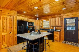 a kitchen with wooden cabinets and a black refrigerator at The Lovely Cabin in Black Mountain +34 photos