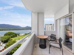 a balcony with a table and chairs and a view of the water at Pullman Cairns International in Cairns