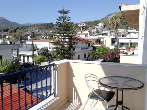 een balkon met een tafel en stoel en uitzicht bij Evgenia Studios in Oud Epidauros