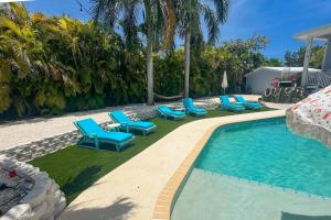 a swimming pool with blue lounge chairs next to it at MA05 Bayfront Sunset Oasis in Marathon