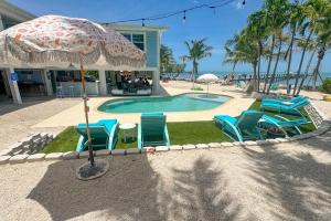 a group of chairs and an umbrella next to a swimming pool at MA05 Bayfront Sunset Oasis in Marathon