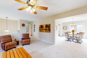 a living room with a ceiling fan and a table at Come Together Place in Candler