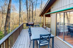 a wooden deck with a table and chairs on it at The Nunv Cabin in Brevard