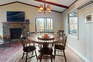 a dining room with a table and a fireplace at The Nunv Cabin in Brevard