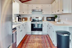 a kitchen with white cabinets and a rug on the floor at The Nunv Cabin in Brevard +33 photos