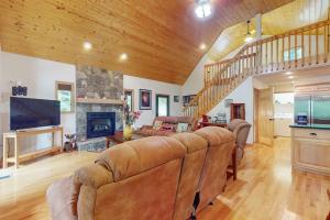 a living room with a couch and a fireplace at Talking River Chalet in Murphy