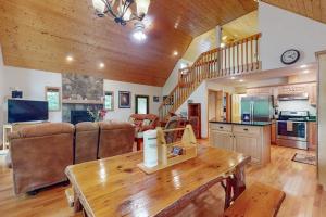 a large living room with a table and a kitchen at Talking River Chalet in Murphy