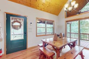 a room with a wooden table and a green door at Talking River Chalet in Murphy