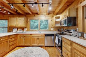 a kitchen with wooden cabinets and appliances in a cabin at Bird's Nest in Saluda