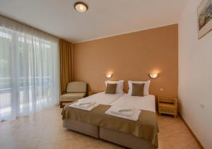 a hotel room with a bed and a chair at Hotel Feniks Lozenets in Lozenets