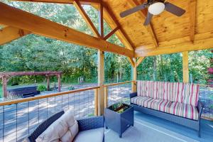 a screened in porch with a couch and a ceiling fan at Deimos Cabin in Mars Hill