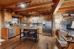 a large kitchen with wooden cabinets and stainless steel appliances at Bear Hug in Sylva +21 photos
