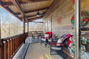 a porch with rocking chairs and a table on it at Bear Hug in Sylva