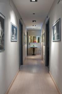 a long hallway with a table and pictures on the walls at B&B Best Vatican in Rome