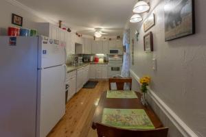 a kitchen with a white refrigerator and a wooden table at The Reed House in Dillsboro