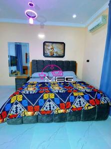 a bedroom with a large bed with a colorful quilt at Meg Apartment in Alimosho