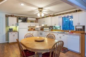 a kitchen with a wooden table with chairs and a sink at Creekside Lodge in Franklin